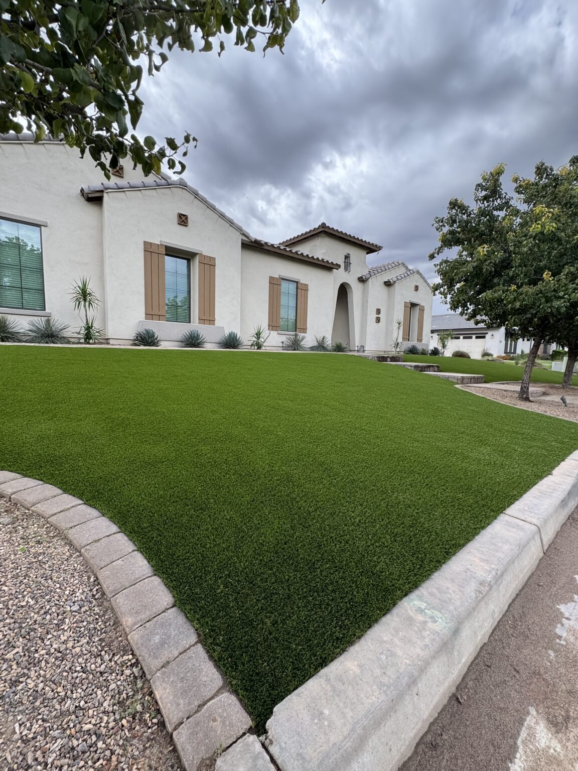 Front yard in Scottsdale featuring Diamond Series artificial grass by All Valley Turf with clean paver borders and desert landscaping.